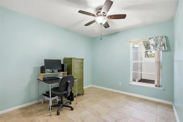 a view of a workspace with furniture and a window