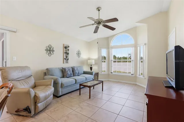 a living room with furniture a flat screen tv and a window