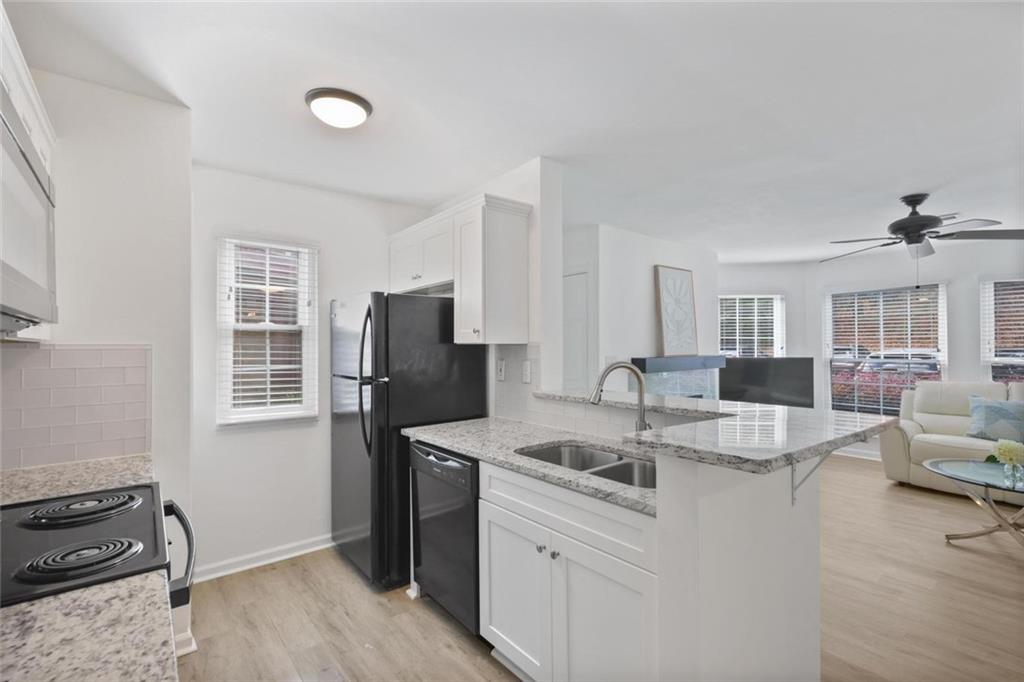 102 Hawkstone Way Alpharetta, GA 30022 - Photo 7 of 22 a kitchen with kitchen island granite countertop a sink stove and refrigerator
