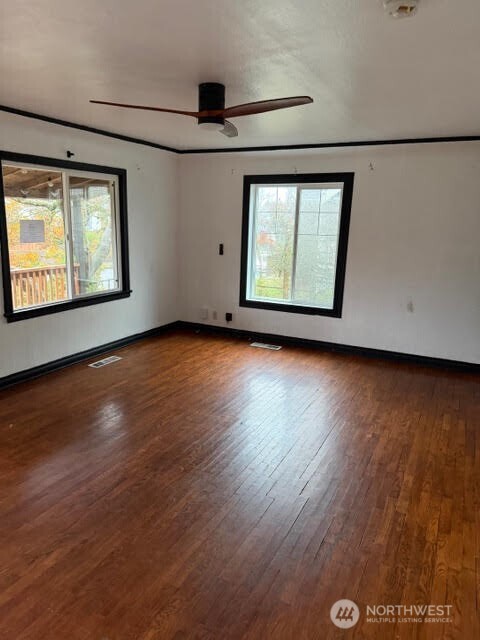 3715 Spokane Street Tacoma, WA 98404 - Photo 7 of 22 an empty room with wooden floor and windows