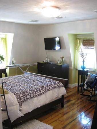 73 Walnut Avenue, Unit 3 Boston, MA 02119 - Photo 15 of 19 a bedroom with a bed and wooden floor