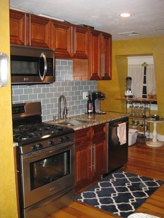 73 Walnut Avenue, Unit 3 Boston, MA 02119 - Photo 4 of 19 a kitchen with stainless steel appliances granite countertop a stove a sink and a microwave