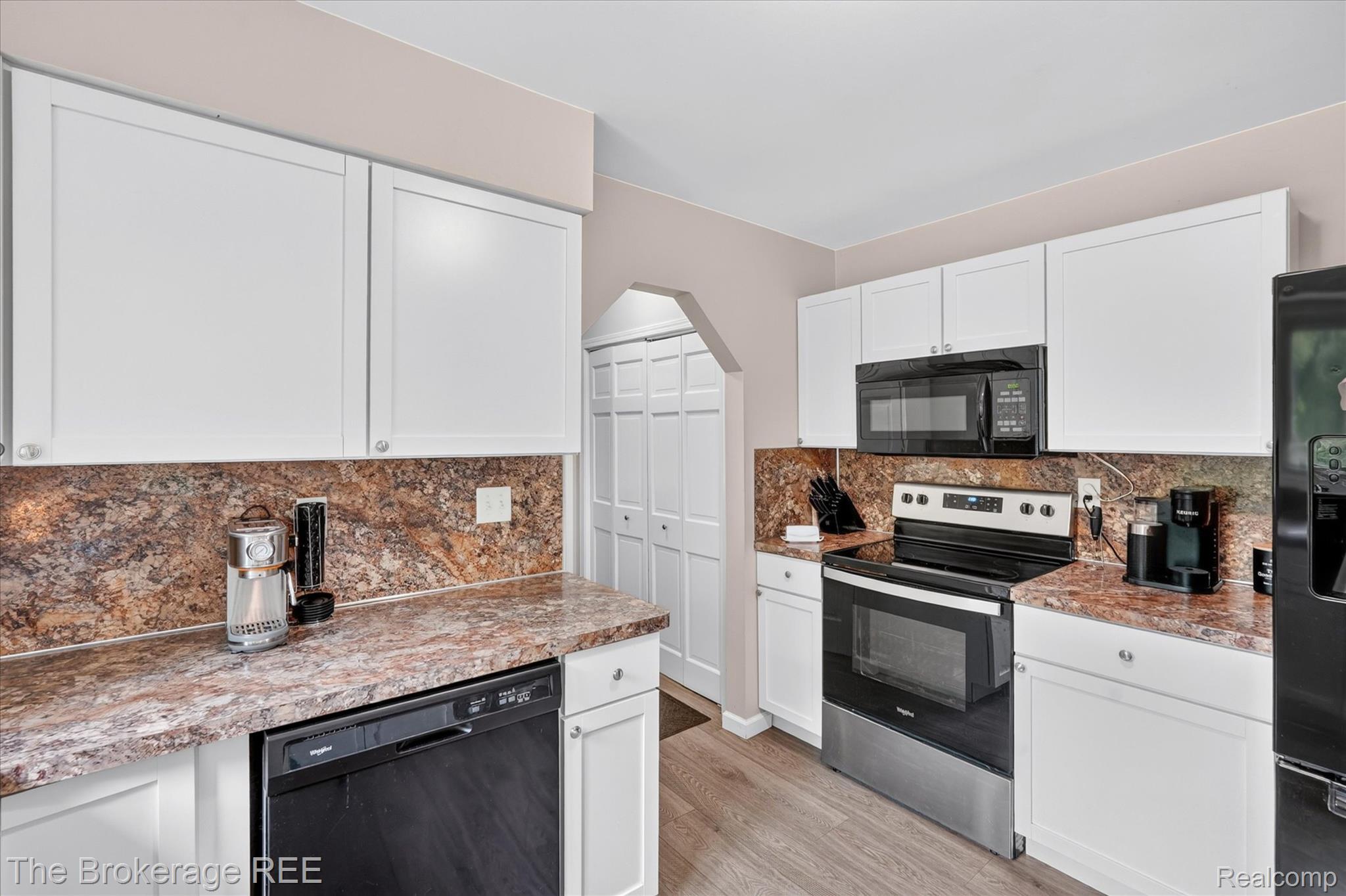 13269 North Genesee Road Clio, MI 48420 - Photo 19 of 67 Kitchen featuring white cabinetry, patterned countertops, and wood-finish flooring