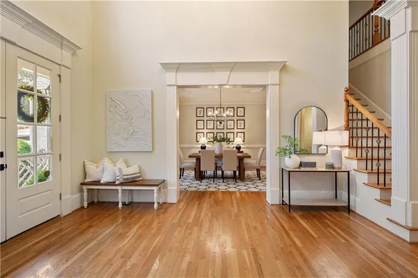 a kitchen with stainless steel appliances granite countertop a stove top oven a sink dishwasher a dining table and chairs with wooden floor