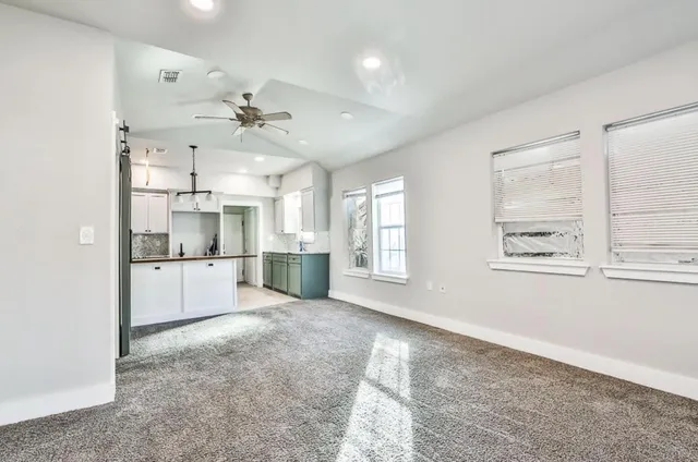 a open kitchen with white cabinets and white appliances