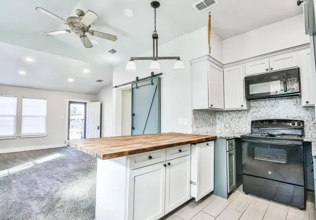 a kitchen with stainless steel appliances granite countertop a sink a stove and a refrigerator