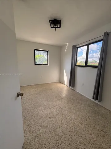 an empty room with windows and closet