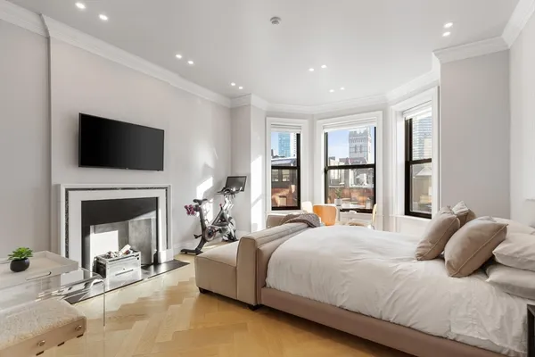 a bedroom with a bed a fireplace and a television