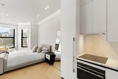 a bedroom with a bed and a potted plant