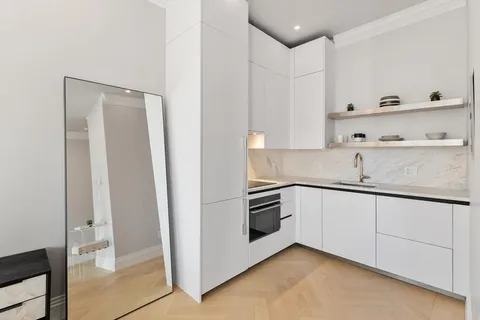 a kitchen with granite countertop white cabinets and white appliances