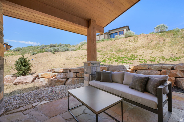 10646 North Reflection Ridge Hideout, UT 84036 - Photo 36 of 43 Covered patio with a wood-plank ceiling, stone paver flooring, and a stone-clad structural column