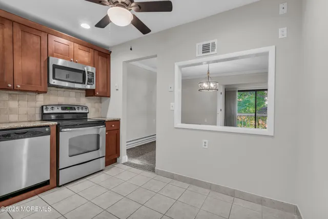 a kitchen with stainless steel appliances granite countertop a stove a microwave and a refrigerator