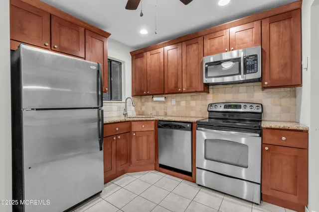 a kitchen with stainless steel appliances granite countertop a refrigerator stove a sink and dishwasher