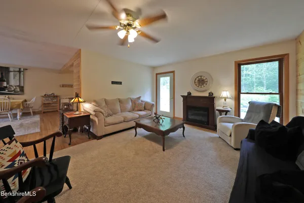 a living room with furniture fireplace and a large window