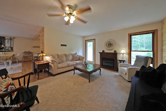 a living room with furniture fireplace and a large window
