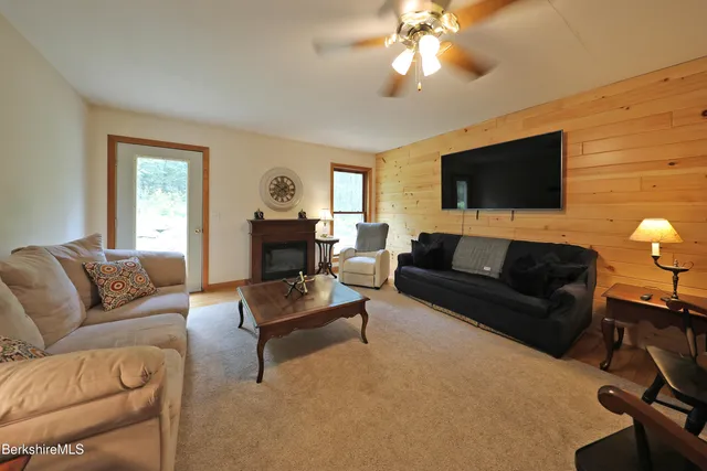 a living room with furniture a flat screen tv and a fireplace