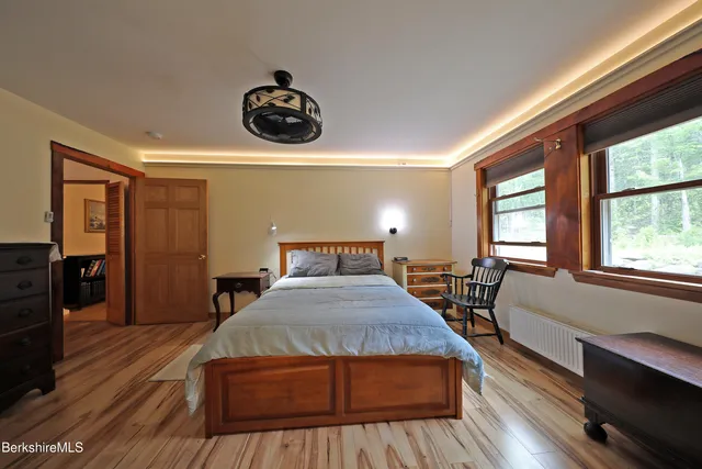 a bedroom with a bed and wooden floor