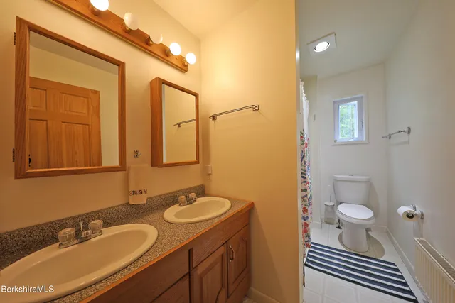 a bathroom with a granite countertop sink toilet and shower