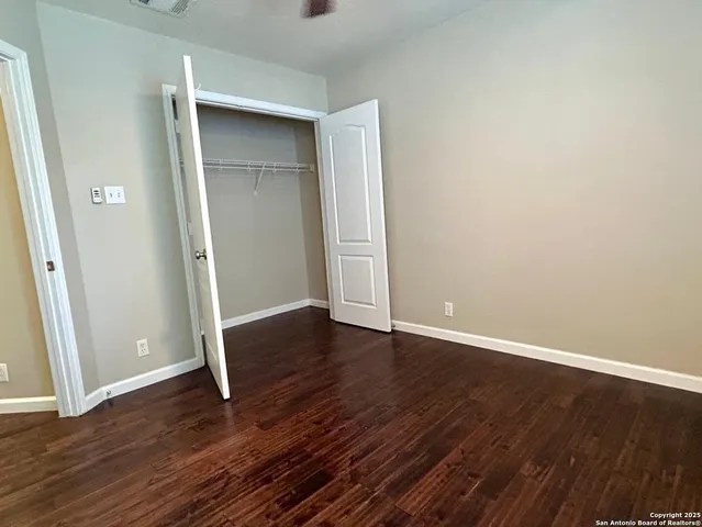 an empty room with wooden floor and closet