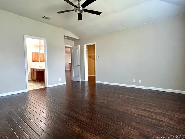 a view of a livingroom with wooden floor and a ceiling fan