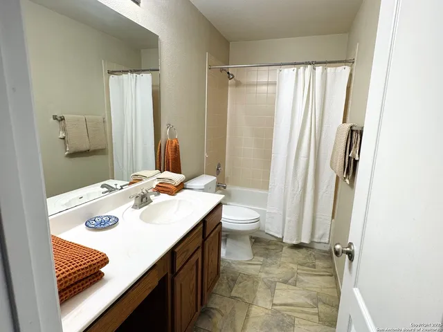 a bathroom with a sink a toilet and a mirror