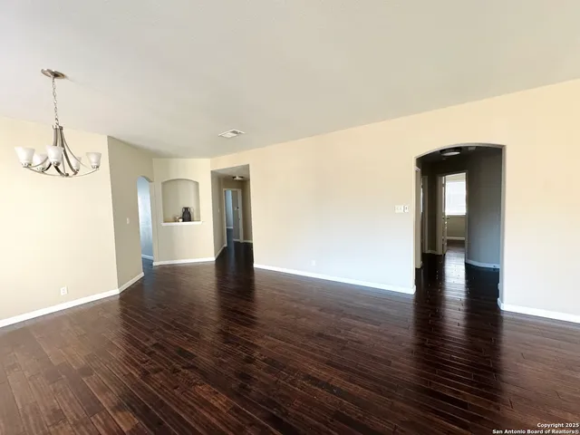a view of empty room with wooden floor