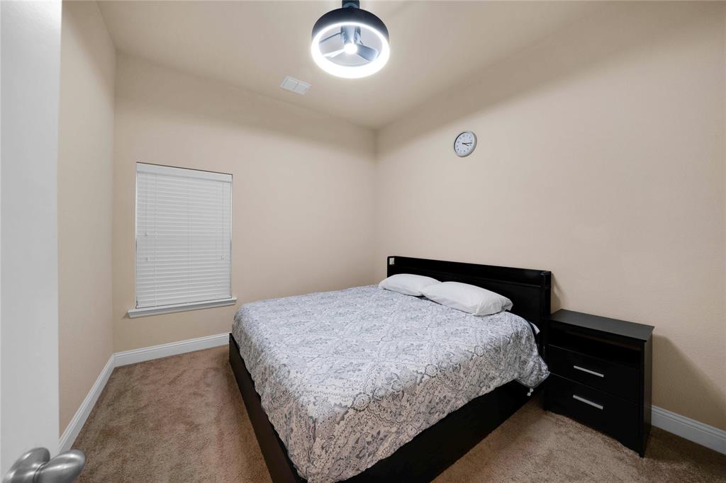 7024 Green Field Street Little Elm, TX 76227 - Photo 13 of 27 a bedroom with a bed and a table