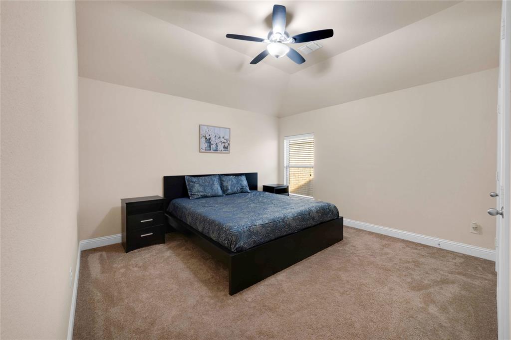 7024 Green Field Street Little Elm, TX 76227 - Photo 16 of 27 a bedroom with a bed chandelier and a window