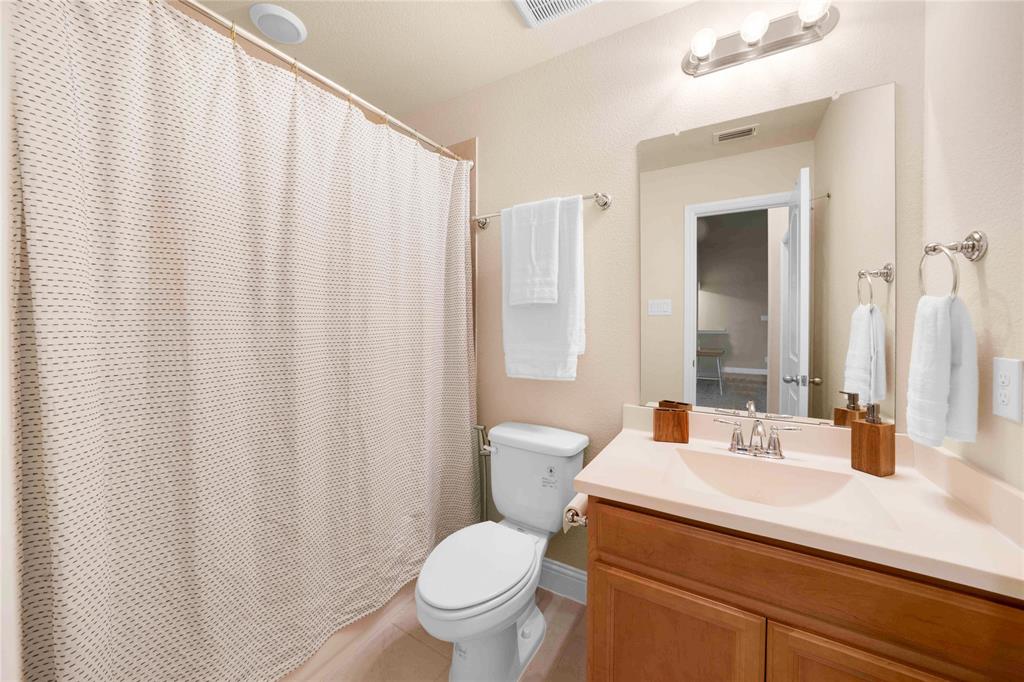 7024 Green Field Street Little Elm, TX 76227 - Photo 17 of 27 a bathroom with a sink a toilet and shower curtain