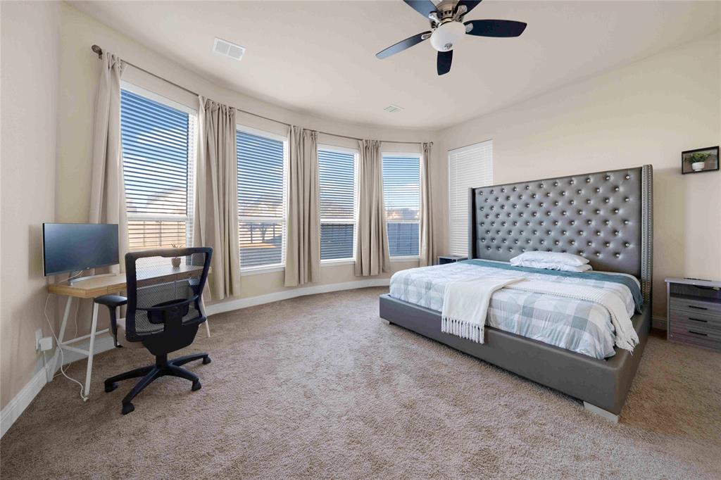 7024 Green Field Street Little Elm, TX 76227 - Photo 8 of 27 a bedroom with a bed a chair and a chandelier