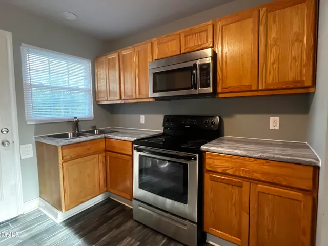 a kitchen with stainless steel appliances granite countertop a stove a microwave and a sink