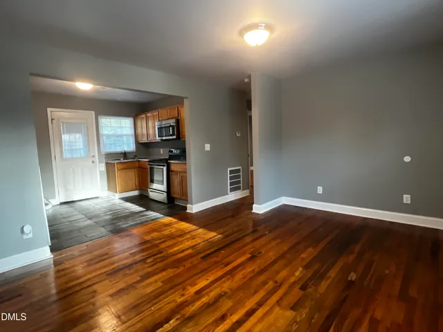 a view of empty room with wooden floor