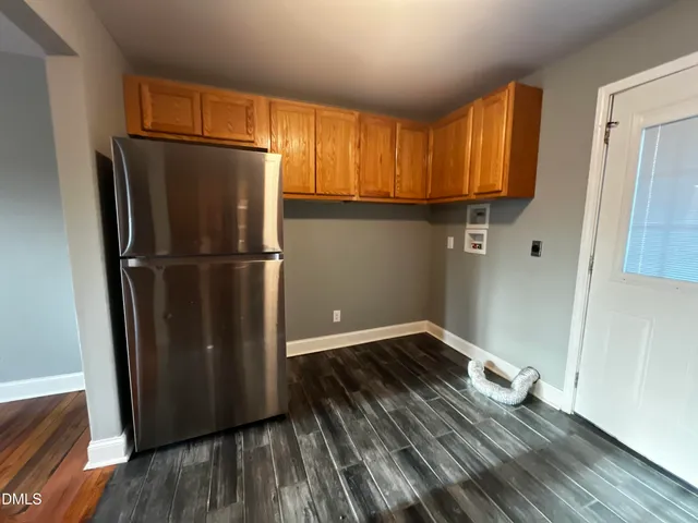 a view of a kitchen with wooden floor and a refrigerator