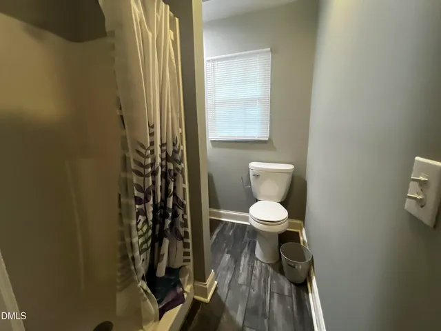 a bathroom with a toilet a sink and a window