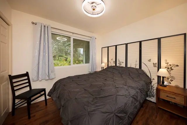 a bedroom with a bed window and a table in it