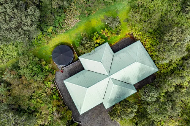 an aerial view of a house with swimming pool and wooden fence