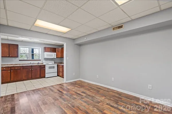 a view of a kitchen with wooden floor and electronic appliances
