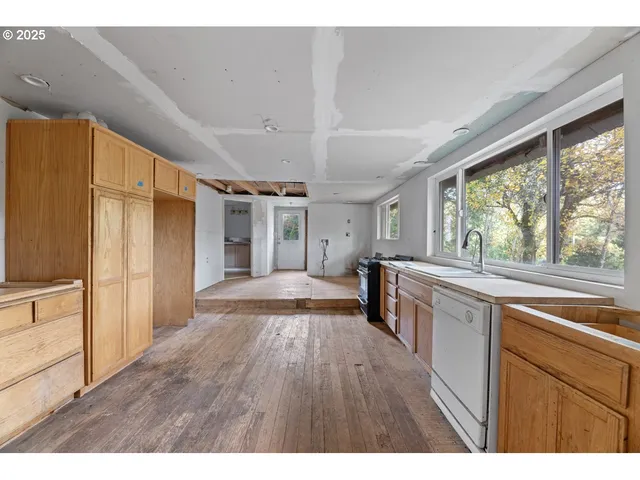 a open kitchen with kitchen island wooden floors and stainless steel appliances