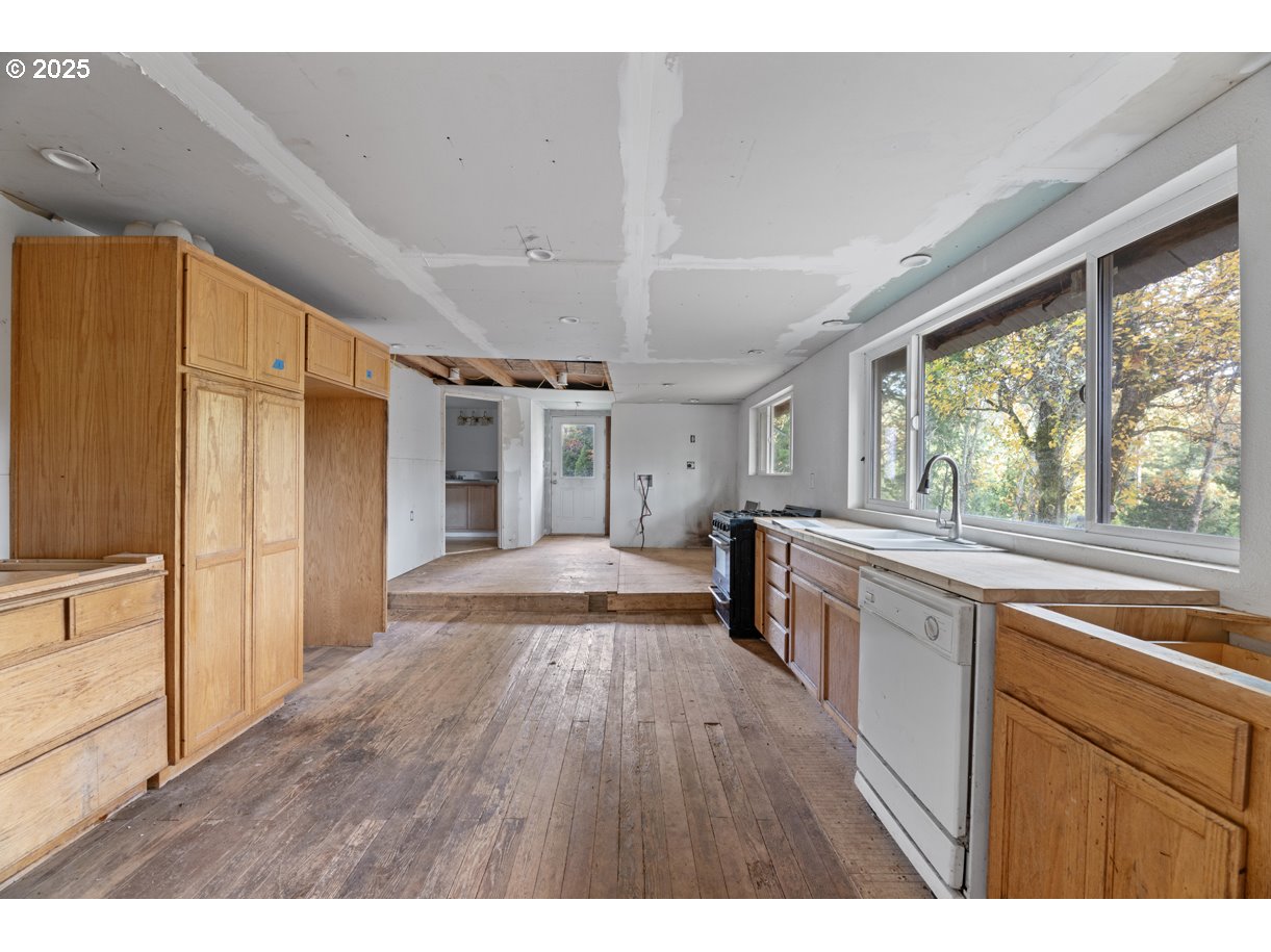 1480 Bridge Lane Wolf Creek, OR 97497 - Photo 25 of 28 a open kitchen with kitchen island wooden floors and stainless steel appliances