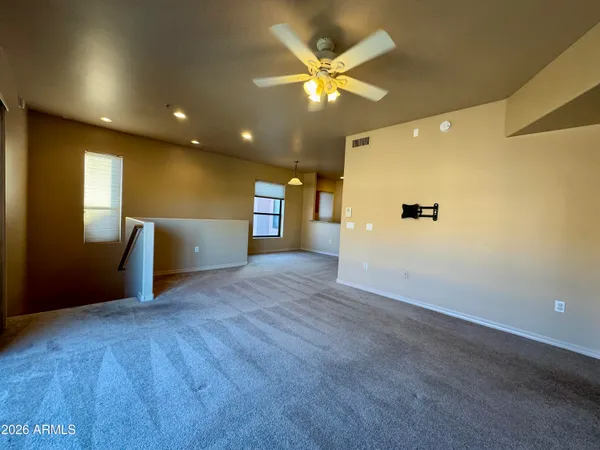 a view of a livingroom with a ceiling fan and window