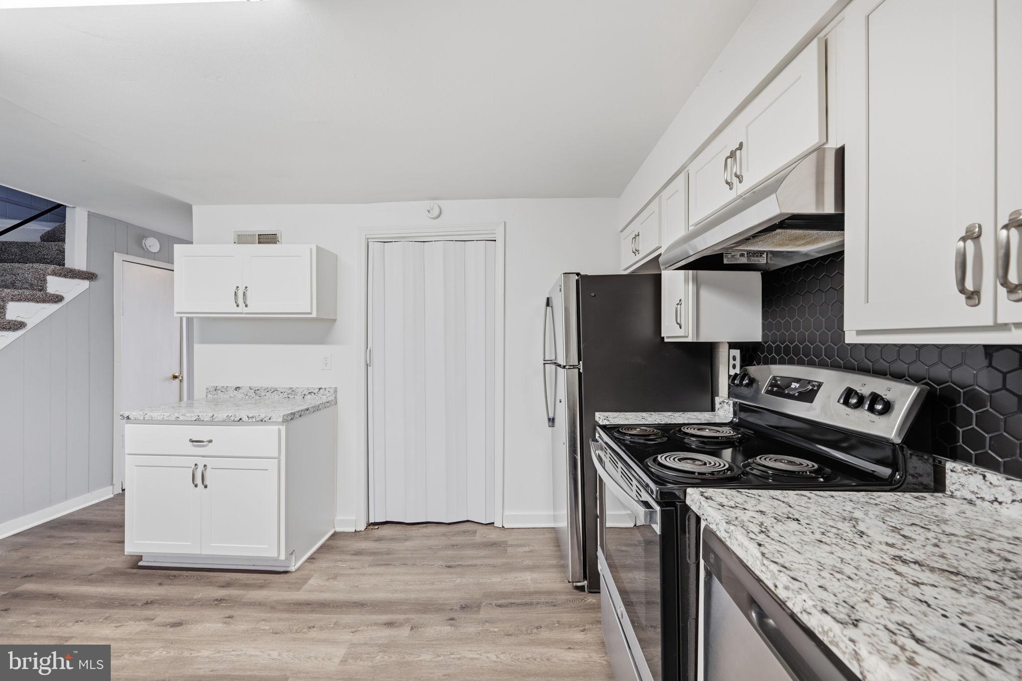 7911 Bank Street Baltimore, MD 21224 - Photo 11 of 40 a kitchen with stainless steel appliances granite countertop a stove and a refrigerator