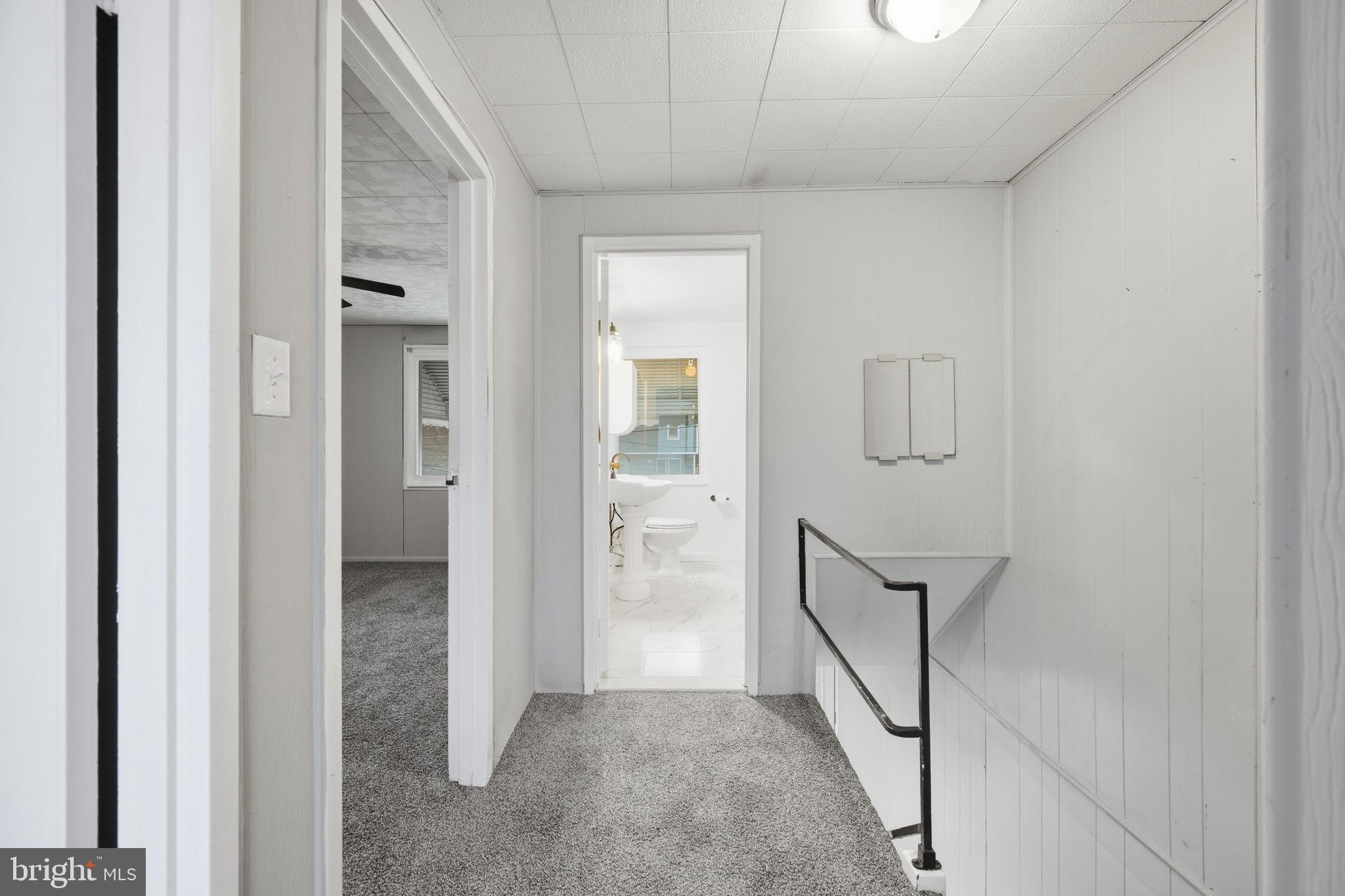 7911 Bank Street Baltimore, MD 21224 - Photo 19 of 40 a view of a hallway with wooden floor and staircase