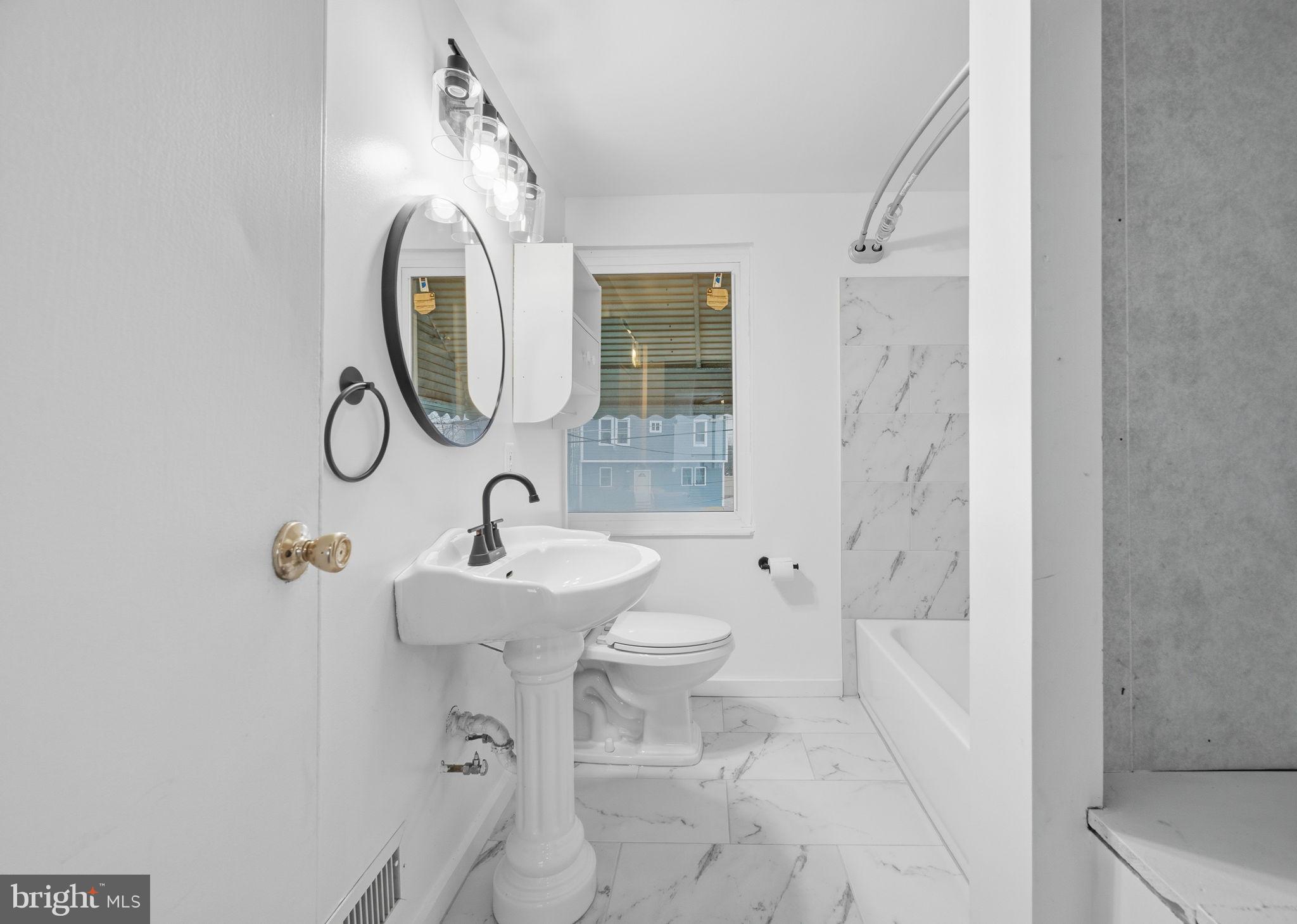 7911 Bank Street Baltimore, MD 21224 - Photo 23 of 40 a bathroom with a sink toilet and shower