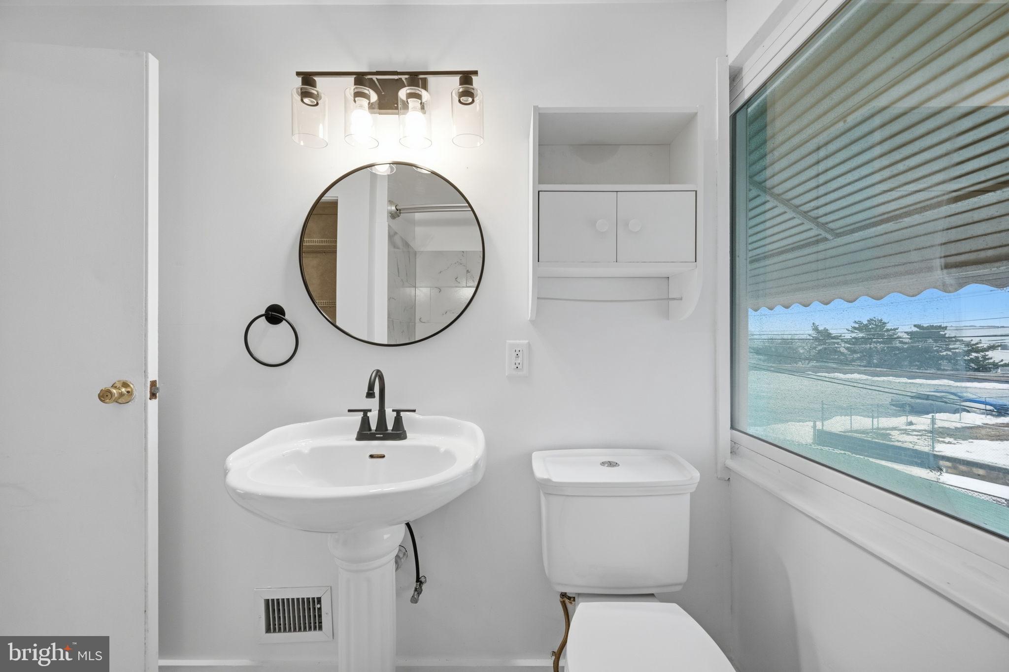 7911 Bank Street Baltimore, MD 21224 - Photo 24 of 40 a bathroom with a toilet sink and mirror