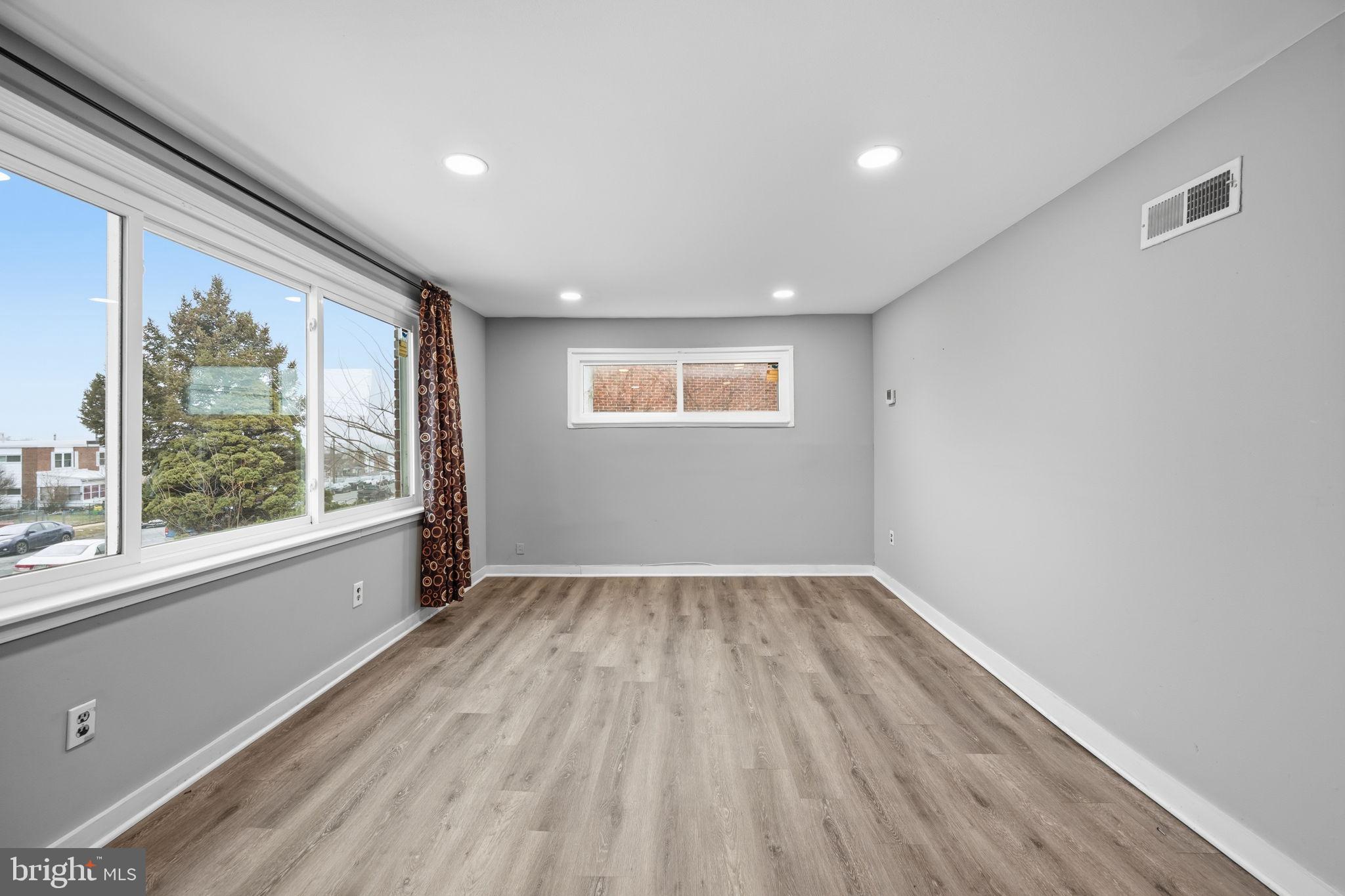 7911 Bank Street Baltimore, MD 21224 - Photo 5 of 40 an empty room with wooden floor and windows