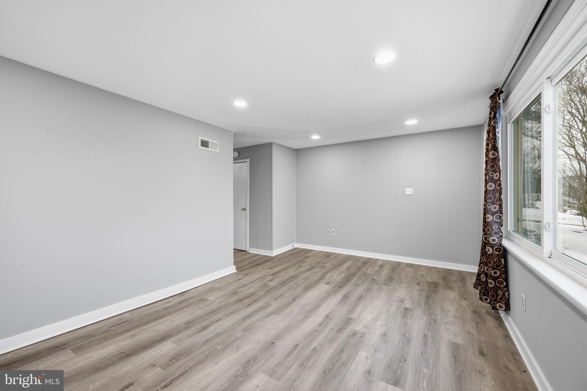 7911 Bank Street Baltimore, MD 21224 - Photo 6 of 40 wooden floor in an empty room with a window