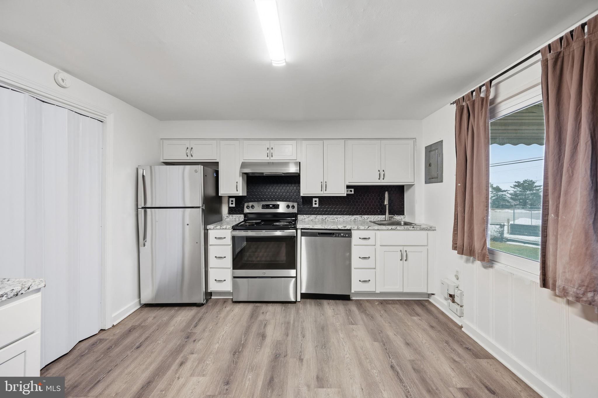 7911 Bank Street Baltimore, MD 21224 - Photo 8 of 40 a kitchen with stainless steel appliances a refrigerator sink and microwave