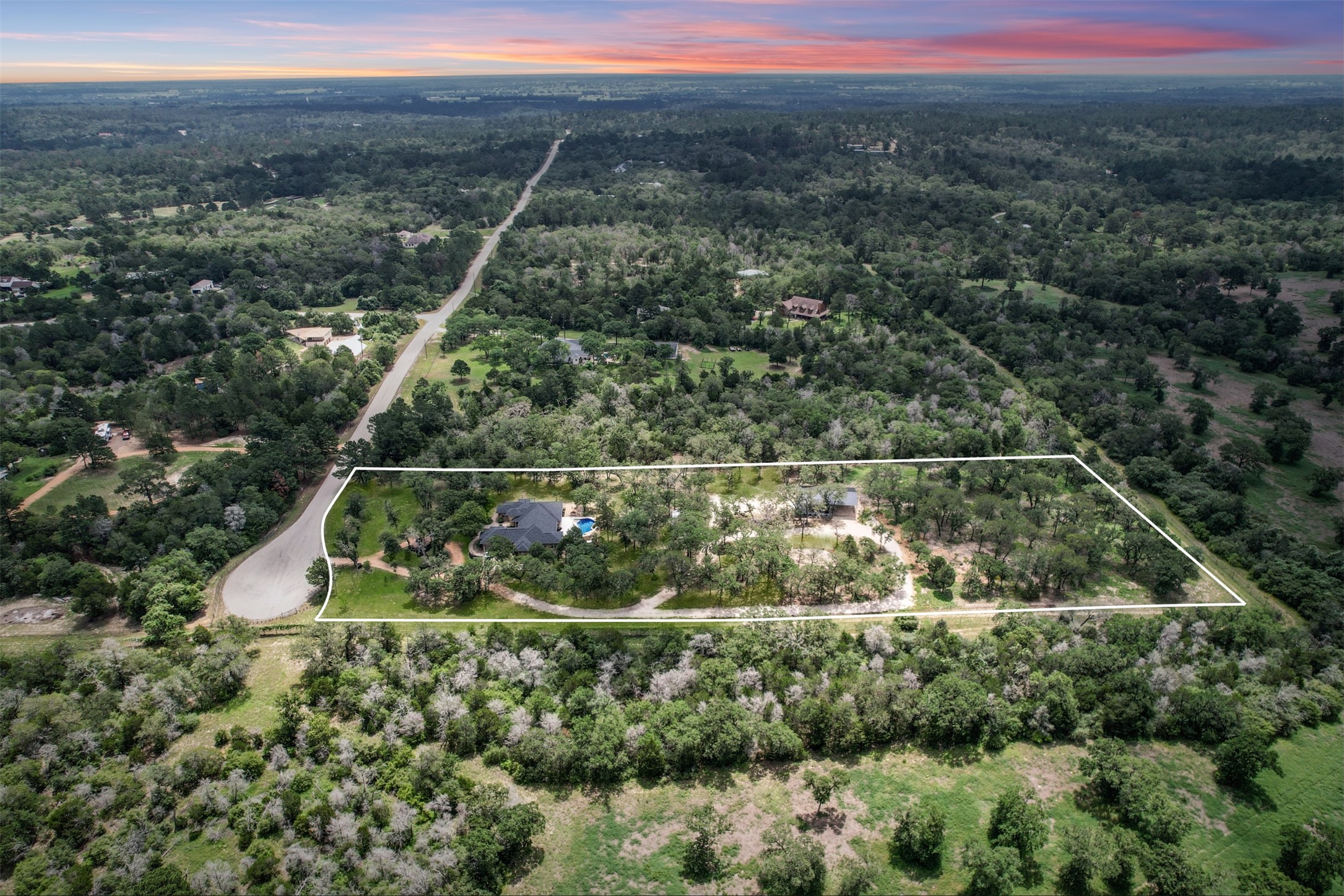 387 Corral Road Smithville, TX 78957 - Photo 1 of 40 Expansive rural property featuring a main residence with a dark-tiled roof and an integrated swimming pool