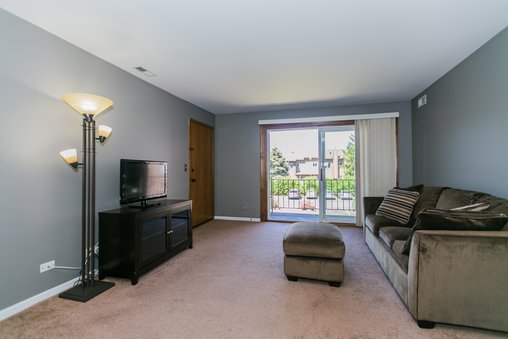 1903 West Golf Road, Unit 2A Mount Prospect, IL 60056 - Photo 3 of 20 a living room with furniture a flat screen tv and a window