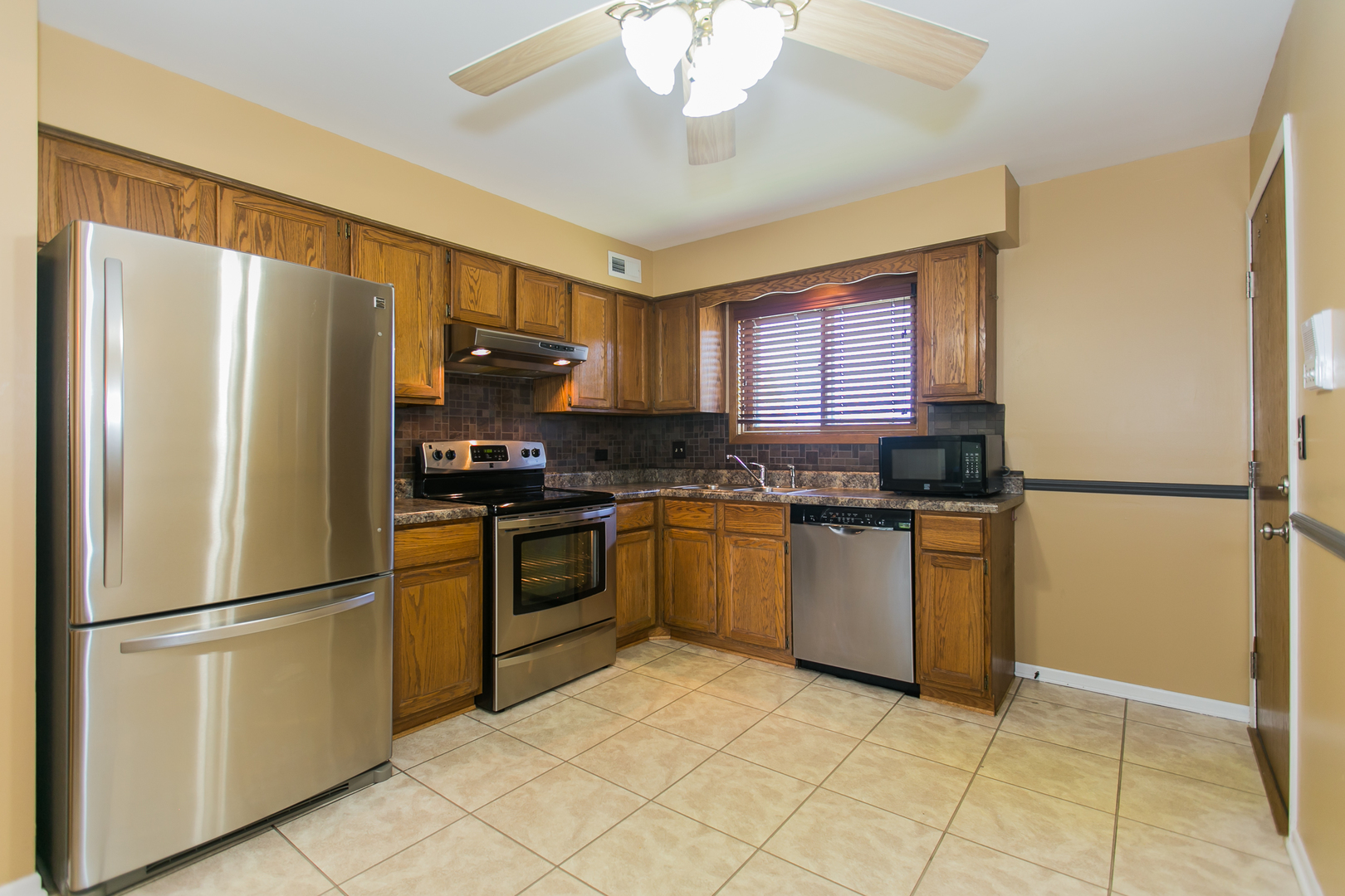 1903 West Golf Road, Unit 2A Mount Prospect, IL 60056 - Photo 8 of 20 a kitchen with granite countertop a refrigerator and a stove top oven